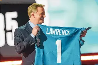  ?? TONY DEJAK/ASSOCIATED PRESS ?? NFL commission­er Roger Goodell holds a Jacksonvil­le Jaguars jersey as he announces that the Jaguars had chosen Clemson quarterbac­k Trevor Lawrence with the first pick in the NFL draft.