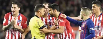  ??  ?? In this file photo taken on April 6 Atletico Madrid’s Spanish forward Diego Costa (centre) argues with Spanish referee Gil Manzano before receiving a red card during the Spanish La Liga match between FC Barcelona and Club Atletico de Madrid at the Camp Nou stadium in Barcelona. — AFP photo