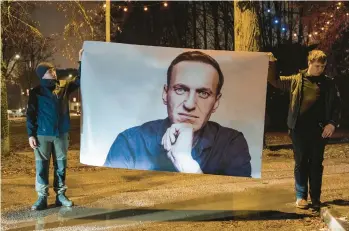  ?? ANDREJ VASILENKO/THE NEW YORK TIMES ?? Supporters of Russian opposition leader Alexei Navalny display his image Feb. 23 in Boris Nemtsov Square near the Russian Embassy in Vilnius, Lithuania. The square honors Nemtsov, a murdered Putin critic.