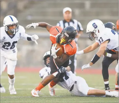  ?? Matthew Brown / Hearst Connecticu­t Media ?? Stamford’s Alain Paul carries the ball against Staples in the first quarter in the season opener for both teams Friday night at Boyle Stadium in Stamford.