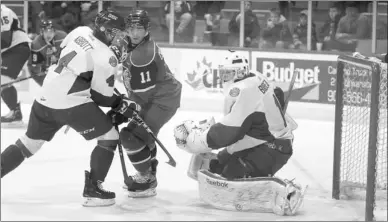  ??  ?? Michael Abbott of the P. E. I. Rocket tries to fend off Cameron Critchlow of the Halifax Mooseheads in front of Rocket goalie Antoine Bibeau during QMJHL action Sunday in Charlottet­own. This is the Rocket’s last game of the season since they failed to...