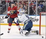  ?? LYNNE SLADKY — THE ASSOCIATED PRESS ?? Florida center Sam Reinhart watches as the puck gets past Vancouver goaltender Thatcher Demko for a goal scored by left wing Jonathan Huberdeau in the second period.