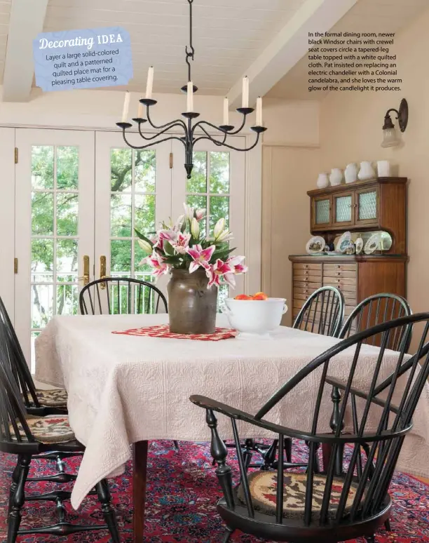  ??  ?? In the formal dining room, newer black Windsor chairs with crewel seat covers circle a tapered-leg table topped with a white quilted cloth. Pat insisted on replacing an electric chandelier with a Colonial candelabra, and she loves the warm glow of the candleligh­t it produces.