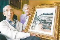  ?? JOHN GIBBINS U-T FILE ?? Claude Cassirer, with his wife, Beverly, holds a reproducti­on of a Camille Pissarro painting.