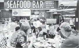  ?? DARRYL DYCK THE CANADIAN PRESS ?? People eat at a seafood bar at T&amp;T Supermarke­t’s newest location, in Richmond, B.C., on Aug. 21, 2018. Shoppers can purchase fresh seafood in the store and have it steamed or baked to be eaten on-site.