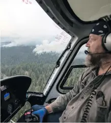  ?? DARRYL DYCK/THE CANADIAN PRESS ?? Helicopter pilot Joe Shupac, of Mayerthorp­e, flies past the Shovel Lake wildfire burning near the Nadleh Whut’en First Nation in Fort Fraser, B.C., on Thursday.