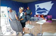  ?? NWA Democrat-Gazette/JASON IVESTER ?? Austin Comiskey (from left), Mike Vasquez and Drew Clark, all with Roark Group, set up a television stand Wednesday in the seating area overlookin­g the 18th green at Pinnacle Country Club in Rogers. Events begin Monday for the LPGA Walmart NW Arkansas...