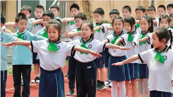  ??  ?? Students are taking a PE class. PE classes have been specially designed to help student gradually develop their bodies.