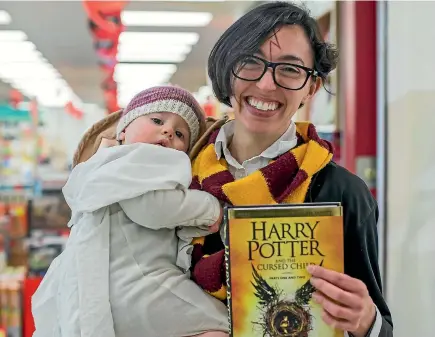  ?? PHOTO: FAIRFAX NZ ?? Avid Harry Potter fan Sara Epperson and her 13-month-old daughter Milly, lined up at Whitcoulls South City, Christchur­ch, to grab a copy of the new title