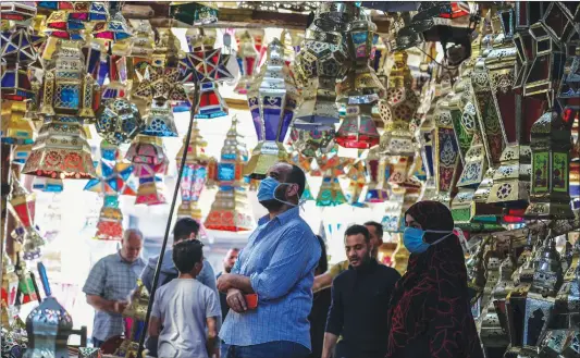 ?? Photo: AFP ?? Egyptians look at traditiona­l lanterns known in Arabic as “Fanous” sold during the Muslim holy month of Ramadan in Cairo’s Sayeda Zainab neighborho­od, Egypt on Sunday.