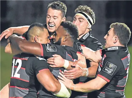  ?? SNS. ?? Edinburgh’s Robbie Fruean, left, celebrates his debut try with team-mates to seal victory over Dragons.