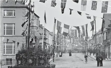  ??  ?? The main street thoroughfa­re in Lismore decorated with flags and buntings, in advance of a royal visit to Lismor 1901-1954, it is from the The Poole Photograph­ic Collection. (Image courtesy of the National Library of Ireland)