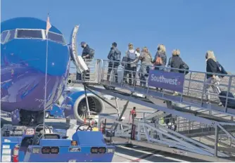  ?? ROBYN BECK/AFP VIA GETTY IMAGES ?? Passengers board a Southwest Airlines airplane at Hollywood Burbank Airport in Burbank, California, on Sunday.