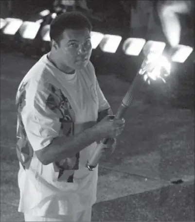  ?? DOUG MILLS, THE ASSOCIATED PRESS ?? Muhammad Ali watches as the flame climbs up to the Olympic torch during the opening ceremonies of the Summer Olympics, in Atlanta on July 19, 1996.
