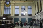  ?? SETH WENIG — AP PHOTO ?? In this Monday photo, commuters walk past boarded up track entrances at Hoboken Terminal in Hoboken, N.J., after the Sept. 29 commuter train crash. New Jersey Transit has said six more tracks will open at 4 a.m. Monday at Hoboken Terminal, which...