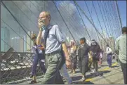  ?? (AP/Mark Lennihan) ?? People walk over New York’s Brooklyn Bridge from Manhattan to Brooklyn following the collapse of both World Trade Center towers on Sept. 11, 2001.