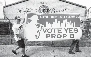  ?? Brett Coomer / Staff photograph­er ?? Houston firefighte­rs Jason Beasley left, and Bucky Glenn campaign in favor of Propositio­n B on Tuesday.