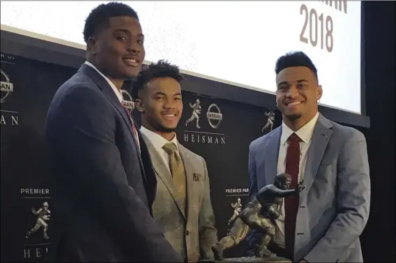  ??  ?? Heisman Trophy finalists (from left) Dwayne Haskins, from Ohio State, Kyler Murray, of Oklahoma, and Tua Tagovailoa, pose with the Heisman Trophy at the New York Stock Exchange, on Friday, in New York. AP PHOTO/RALPH RUSSO