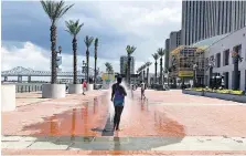  ?? PHOTOS: ANDREA SACHS/THE WASHINGTON POST ?? A woman escapes the humidity in water spouts at Woldenberg Riverfront Park.