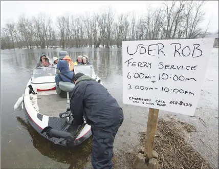  ?? CP PHOTO ?? Rob Dekany, known locally as Uber Rob, ferries stranded passengers at Darlings Island, N.B., on Thursday as the Kennebecas­is River  ooded the only road into the community. Dekany has been o ering the service all week and refuses to accept any payment.