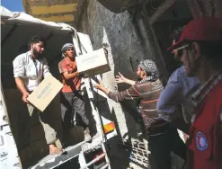  ?? —AFP ?? AL-NASHABIYAH, Syria: A picture taken on July 30, 2017 shows aid packages from the United Nations and the Syrian Arab Red Crescent (SARC) being delivered to locals in the rebel-held town.