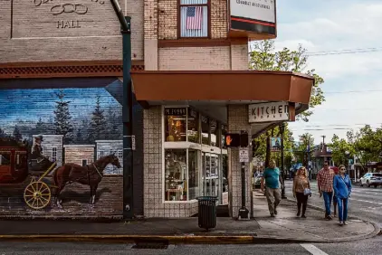  ?? Photos by Gabrielle Lurie/The Chronicle ?? People stroll through downtown Grants Pass, Ore. On Monday, the U.S. Supreme Court will hear arguments in a case brought by unhoused residents here against the city’s anti-camping rules.