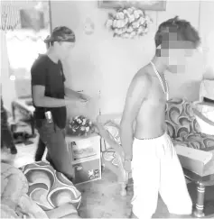  ??  ?? One of the suspects being detained by Nada Keningau enforcemen­t officers.