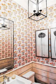  ??  ?? Bold marigold wallpaper brightens the Davises’ powder bathroom.