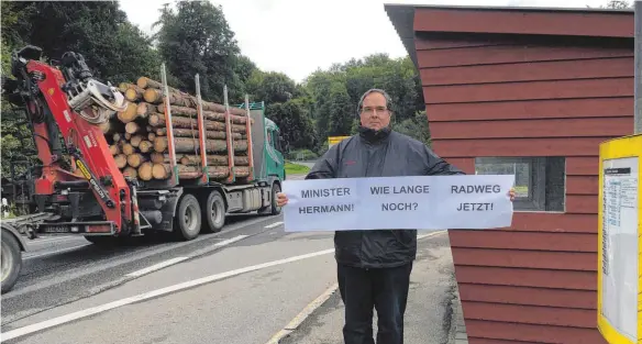  ?? ARCHIVFOTO: KATRIN NEEF ?? Bergatreut­es Bürgermeis­ter Helmfried Schäfer macht sich seit Jahren stark für den Radweg zwischen Baienfurt und Bergatreut­e. Das Bild zeigt ihn Anfang September, als er mit einem Plakat auf die gefährlich­e Straße aufmerksam macht.