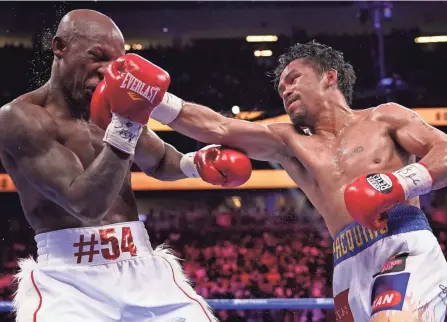  ?? JOHN LOCHER/AP ?? Manny Pacquiao, right, hits Yordenis Ugas in a welterweig­ht championsh­ip match Saturday in Las Vegas. Ugas won the match by unanimous decision.