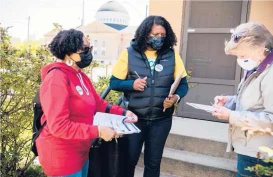  ?? DUSTIN FRANZ/THE NEW YORK TIMES ?? Keisha Krumm, center, executive director of the Greater Cleveland Congregati­ons, and volunteers prepare to sign up local residents for a vaccinatio­n event May 1 at a church across the street in Cleveland. The organizati­on is a coalition of faith communitie­s that has held vaccine clinics at its member churches.