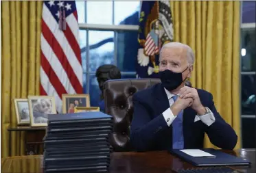  ?? EVAN VUCCI—ASSOCIATED PRESS ?? FILE - In this Jan. 20, 2021, file photo President Joe Biden waits to sign his first executive order in the Oval Office of the White House in Washington. As one of his first acts, Biden offered a sweeping immigratio­n overhaul that would provide a path to U.S. citizenshi­p for the estimated 11 million people who are in the United States illegally. It would also codify provisions wiping out some of President Donald Trump’s signature hard-line policies, including trying to end existing, protected legal status for many immigrants brought to the U.S. as children and crackdowns on asylum rules.