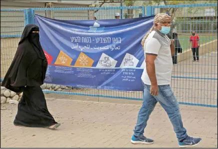  ??  ?? فلسطينيان من عرب 48 في طريقها للإدلاء بصوتهما في الانتخابات الإسرائيلي­ة