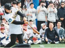  ?? Yonhap ?? President Yoon Suk Yeol, front row second from right, watches a batting demonstrat­ion by Kim Ha-seong of the San Diego Padres during the Padres’ youth baseball clinic at a park in Seoul, Saturday.