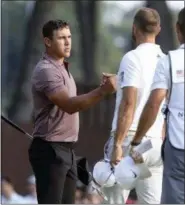  ?? CHRIS PEDOTA — THE RECORD VIA AP ?? Brooks Koepka, left, shakes hands with Dustin Johnson after they completed the second round of the Northern Trust PGA golf tournament at Ridgewood Country Club in Paramus, N.J., Friday.