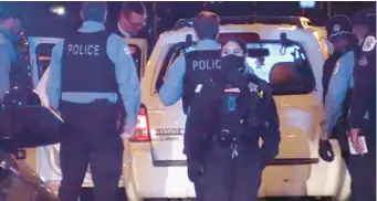  ?? NETWORK VIDEO PRODUCTION­S ?? Chicago Police officers check over the targeted Ford SUV near 111th Street and Hamlet Avenue after the Interstate 57 shooting that left three dead and three wounded Sunday.