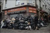  ?? LEWIS JOLY — THE ASSOCIATED PRESS ?? A man walks past piles of garbage in Paris on Monday.