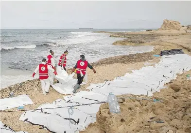  ?? AL-ZAWIYAH BRANCH — LIBYAN RED CRESCENT / AFP ?? Libyan Red Crescent volunteers recovering the bodies of 74 migrants that washed ashore on Libya’s northern coast. The humanitari­an group said there are bodies still floating out at sea, but it has no means to retrieve them.