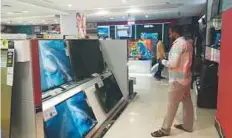  ?? Arshad Ali/Gulf News ?? Customers compare television sets in an electronic­s shop in Dubai. With the football broadcast available in 4K, some retailers are promoting models that are 4K enabled.