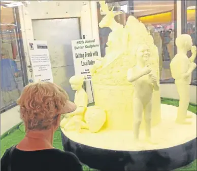  ?? PHOTOS BY JOHN HAEGER — ONEIDA DAILY DISPATCH ?? Fairgoers view the 45th annual Butter sculpture in the Dairy Building at the NYS Fair in Geddes.