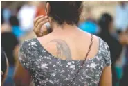  ?? THE ASSOCIATED PRESS ?? Peregrina Vera, a Oaxacan muxe, attends the funeral Monday of a neighbor who family members said did not recover from the shock of Thursday’s magnitude 8.1 earthquake in Juchitan, Mexico. Vera’s tattoo shows a fairy sitting in a canopied chair,...