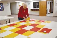  ?? Rachel Dickerson/The Weekly Vista ?? LoGene Test lays out quilt blocks in a pattern during a meeting of Piecemaker­s on Feb. 14 at United Lutheran Church of Bella Vista.