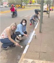  ?? ?? Comerciant­es pintan el cordón de la vereda frente a sus negocios, en el nuevo circuito.