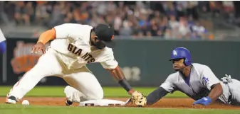  ?? Scott Strazzante / The Chronicle ?? Pablo Sandoval makes the tag but not before losing the ball as the Dodgers’ Yasiel Puig steals third base in the second, part of a series of defensive and baserunnin­g gaffes by the Giants.