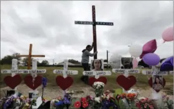  ?? ERIC GAY — THE ASSOCIATED PRESS ?? Miguel Zamora stands a cross for the victims of the Sutherland Springs First Baptist Church shooting at a makeshift memorial, Saturday in Sutherland Springs, Texas. A man opened fire inside the church in the small South Texas community on Sunday,...