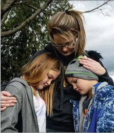  ?? JAKE MAY — THE FLINT JOURNAL VIA AP ?? Vanessa Labrie holds onto her two children, Kiersteyn Fields, 10, and her brother Landon Baker, 8, as they stand in their yard up the road from Oxford High School in Oxford. Gun safety is getting renewed focus following in the wake of the deadliest U.S. school shooting since 2018. For instance, a national program called BESMART intends to educate people about safely storing guns away in order to keep children safe.