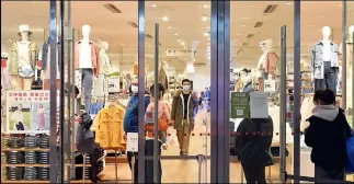  ??  ?? Para controlar el flujo de gente, muchas tiendas exigen que los consumidor­es esperen a cierta distancia de la puerta. Cuando uno sale, el otro entra.