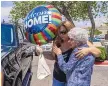  ??  ?? Deborah Lucero, left, hugs Sue Rymarz outside the Kindred Long-Term Acute Care Hospital. Rymarz was on hand to cheer the release of Lucero’s husband.