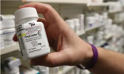  ?? Photograph: George Frey/Reuters ?? A pharmacist holds a bottle of OxyContin made by Purdue Pharma in 2019.