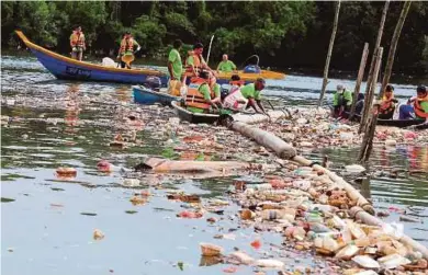  ?? PIC BY ZAIN AHMED ?? Volunteers clearing Sungai Tebrau of garbage during a gotong-royong session in Kampung Bakar Batu, Johor Baru, yesterday.